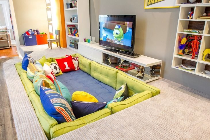 Sill&oacute;n en el suelo con almohadas de colores.