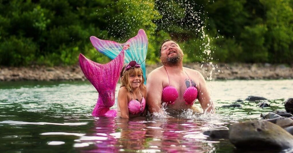 Un padre disfrazado de sirena posa con su hija en una divertida sesión de fotos